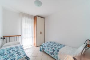 a bedroom with two beds and a window at Residenza Le Altane in Bibione