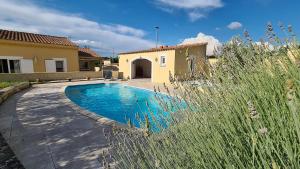 una piscina en un patio junto a una casa en Villa Syrah, en Châteauneuf-du-Pape