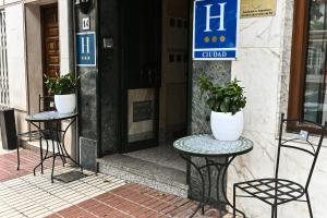 dwa krzesła i stół przed drzwiami w obiekcie Hotel Doña Catalina w Marbelli