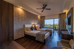 a hotel room with two beds and a balcony at The Baagh Ananta Elite Ranthambore in Khilchipur