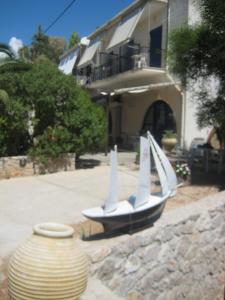 a toy boat with sails sitting outside of a house at Vikos Beach Apartments in Paralía Iríon