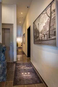 un couloir orné d'une peinture murale et d'un tapis au sol dans l'établissement Hotel Hulsman, à Fauquemont