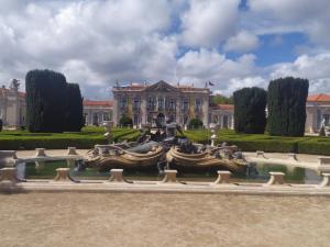 a fountain in front of a building with a house at Casa S Nicolau 2 Near the beach in Lourinhã