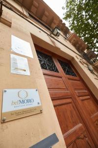 una señal en el lateral de un edificio con una puerta de madera en belMORO - La Dimora Del Capo, en Palermo