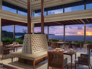 a restaurant with tables and chairs and a view of the ocean at Jumeirah Bali in Uluwatu