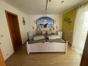 a bedroom with a white bed with a poster on the wall at PENSION JÄGER - der Geheimtipp am Europa-Park in Rust