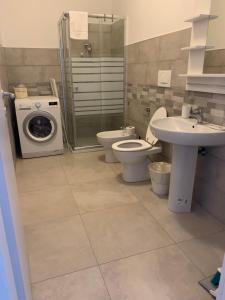 een badkamer met een toilet, een wastafel en een wasmachine bij CASA 8 GIUGNO in Melegnano