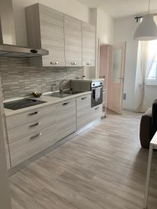 a kitchen with white cabinets and a stove top oven at CASA 8 GIUGNO in Melegnano
