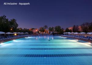 a large swimming pool at night with chairs and umbrellas at Valeria Madina Club - All Inclusive in Marrakech