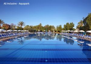 a large swimming pool with chairs and umbrellas at Valeria Madina Club - All Inclusive in Marrakech