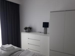 a bedroom with a bed and a dresser with a tv on it at Rewal Resort Klifowa - Morska 3/12 in Rewal