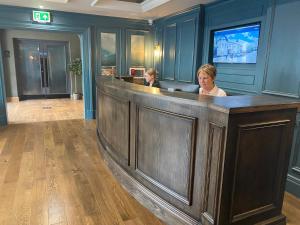 Due donne sedute in un bar nella hall di un hotel di Hillyard House Hotel a Castlewellan