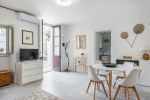 a white living room with a table and chairs at Casa Alchisi - Teatro Romano Cozy Apartment in Catania