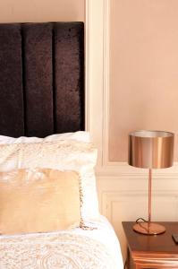 a bedroom with a bed with a lamp on a table at Maison Bellachonne in Bellac