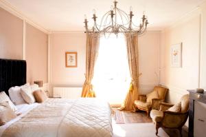 a bedroom with a bed and a chandelier at Maison Bellachonne in Bellac