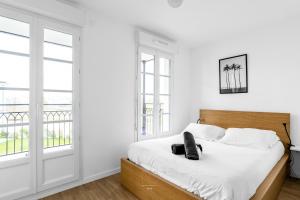 una camera da letto con un letto con pareti e finestre bianche di Disneyland-Paris 8pers,Parking, borne recharge VE, Wifi a Serris
