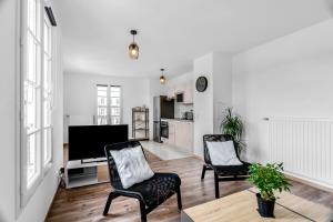 ein Wohnzimmer mit zwei Stühlen und einem Flachbildfernseher in der Unterkunft Disneyland-Paris 8pers,Parking, borne recharge VE, Wifi in Serris