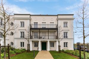 ein großes weißes Haus mit Balkon in der Unterkunft Disneyland-Paris 8pers,Parking, borne recharge VE, Wifi in Serris