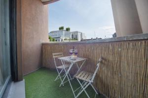 einen kleinen Tisch und zwei Stühle auf dem Balkon in der Unterkunft Sweet Inn - Torre Velasca in Mailand
