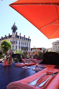 a row of tables with umbrellas on top of them at ibis Styles Le Puy en Velay in Le Puy-en-Velay