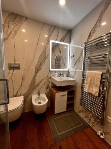 een badkamer met een wastafel, een toilet en een spiegel bij B&B TIVÌTTI in Palermo
