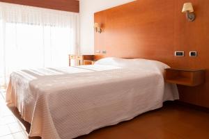 een slaapkamer met een groot bed met een houten wand bij Hotel Novo Muiño in A Guarda +10 foto's