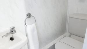 La salle de bains est pourvue de toilettes blanches et d'un lavabo. dans l'établissement Valdene Hotel, à Blackpool
