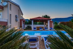 a villa with a swimming pool and a house at Villa Suker - Jacuzzi, Pool, Sauna in Kaštela