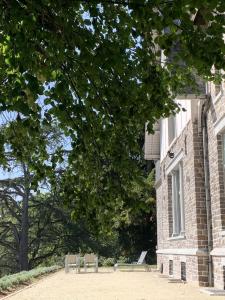two benches sitting in front of a brick building at Un Toit sur les Monts in Esneux +3 photos