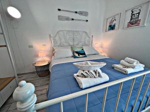 a bedroom with a blue bed with towels on it at Io.te e il mare in Termoli
