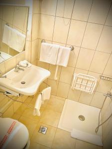 ein Badezimmer mit einem Waschbecken, einem WC und einem Spiegel in der Unterkunft GLARENTZA in Kyllini