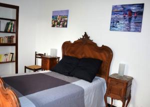 Maison de 5 chambres avec jardin amenage a Les Vans في لي فان: غرفة نوم مع سرير مع لوح خشبي للرأس
