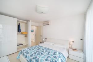 a bedroom with a bed with a blue and white blanket at Residenza Ore Felici in Lignano Sabbiadoro