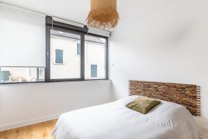 a bedroom with a bed and a large window at Suite in Suresnes