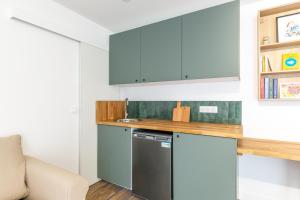 a kitchen with blue cabinets and a dishwasher at Suite in Suresnes