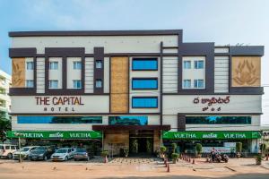 a building with cars parked in front of it at The Capital Hotel in Guntūr