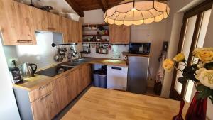 eine Küche mit Holzschränken und Küchengeräten aus Edelstahl in der Unterkunft Independent chalet with breathtaking view in Villar Pellice
