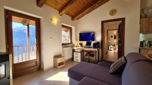 a living room with a purple couch and a desk at Independent chalet with breathtaking view in Villar Pellice