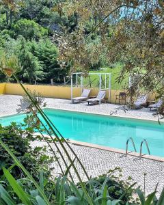 uma piscina com duas espreguiçadeiras ao lado em Quinta Da Torre - Óbidos Country House em Óbidos