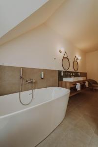 StadtschlainingBurghotel Schlaining的浴室内设有大型白色浴缸。