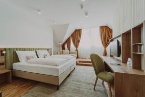 StadtschlainingBurghotel Schlaining的一间卧室，配有一张床、一张书桌和一台电视