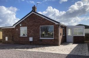 a brick house with a white door and windows at Fully Accessible - Disability Adapted Holiday Cottage - Skegness in Ingoldmells