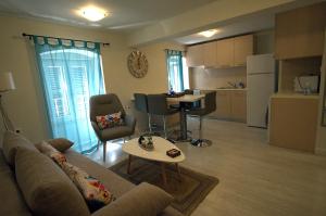 a living room with a couch and a table and a kitchen at Piccolo Centrale in Corfu