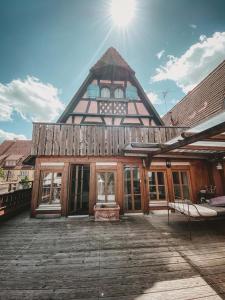 uma grande casa de madeira com o sol no céu em Cafe einzigARTig em Rothenburg ob der Tauber