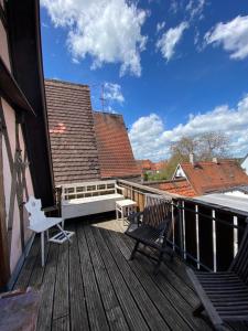 eine Terrasse mit zwei Stühlen und einer Bank darauf in der Unterkunft Cafe einzigARTig in Rothenburg ob der Tauber