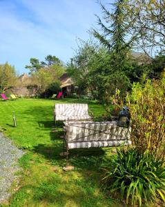twee banken in het gras in een tuin bij Le Clos Montrichard in Montrichard