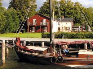 博恩的住宿－Pension Walfischhaus，船停靠在房子前面的码头
