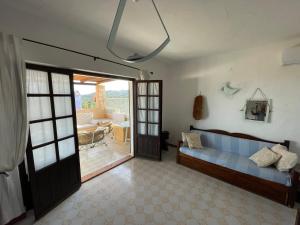 a living room with a blue couch and a sliding glass door at La Terrazza sul Mare in Fort Village +19 photos