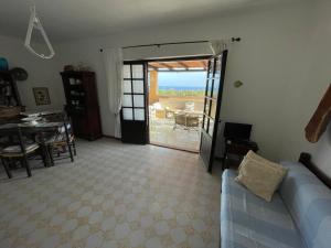 a living room with a couch and a view of a patio at La Terrazza sul Mare in Fort Village
