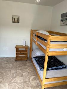 a bedroom with two bunk beds and a night stand at Petite maison au coeur du village in Mesquer